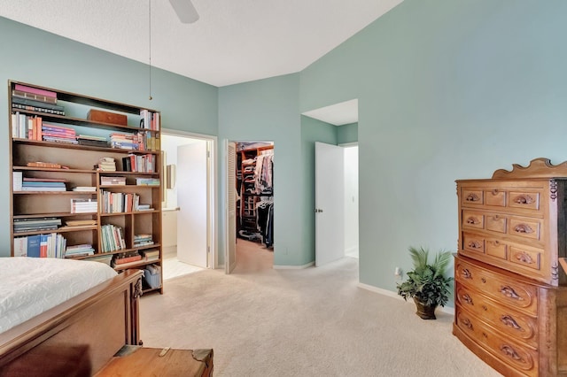 carpeted bedroom with a spacious closet, a closet, and ceiling fan