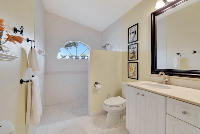 bathroom with toilet, tile patterned flooring, tiled shower, and vanity