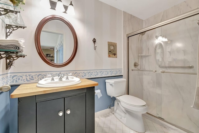 bathroom featuring a shower with shower door, toilet, and vanity