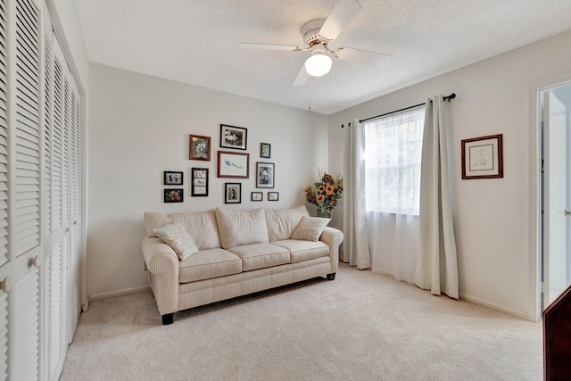 carpeted living room featuring a textured ceiling and ceiling fan