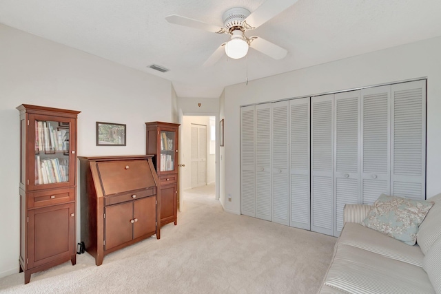 living area with ceiling fan and light colored carpet