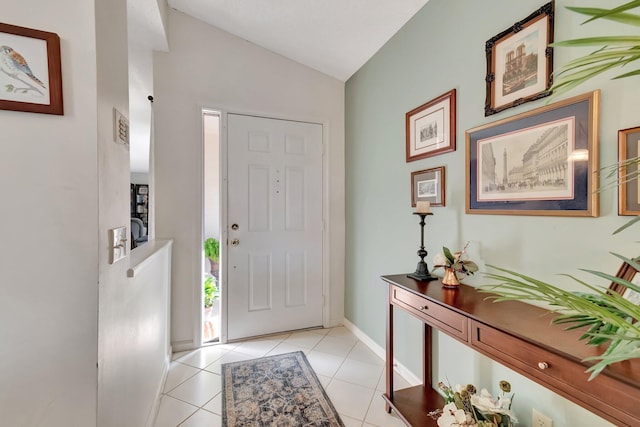 foyer entrance with light tile patterned floors and lofted ceiling