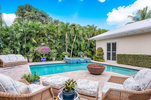 view of swimming pool with a pool with connected hot tub, outdoor lounge area, and a patio