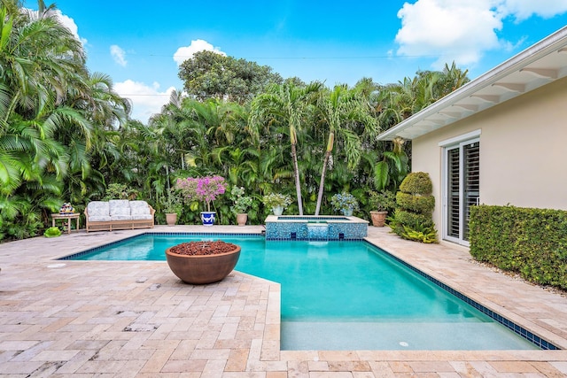 view of pool featuring a patio area and a pool with connected hot tub