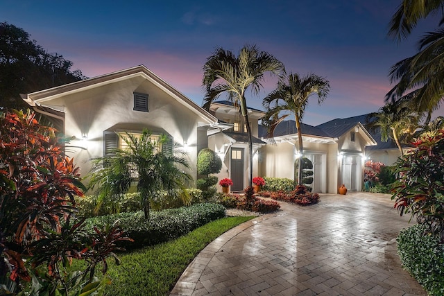 view of front of house featuring a garage, decorative driveway, and stucco siding