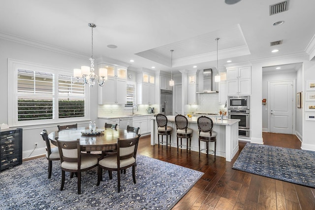 dining room with visible vents, wine cooler, and a tray ceiling