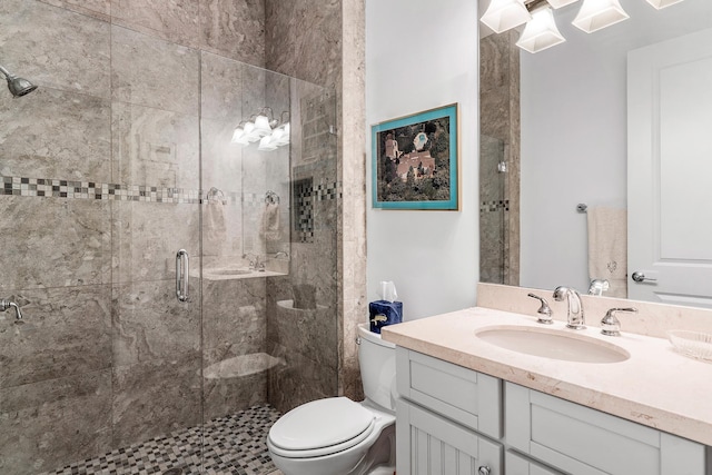 bathroom featuring vanity, a shower stall, and toilet