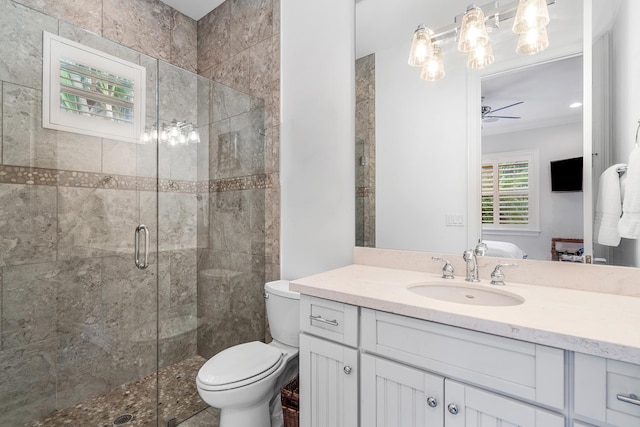 ensuite bathroom featuring ensuite bathroom, toilet, vanity, a ceiling fan, and a shower stall