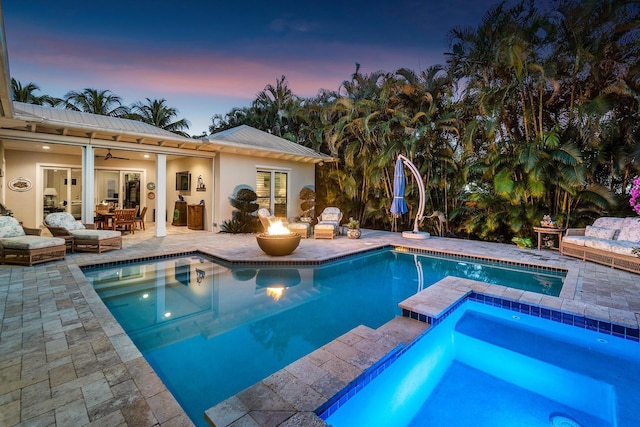 view of swimming pool featuring a fire pit, a patio, ceiling fan, and a pool with connected hot tub