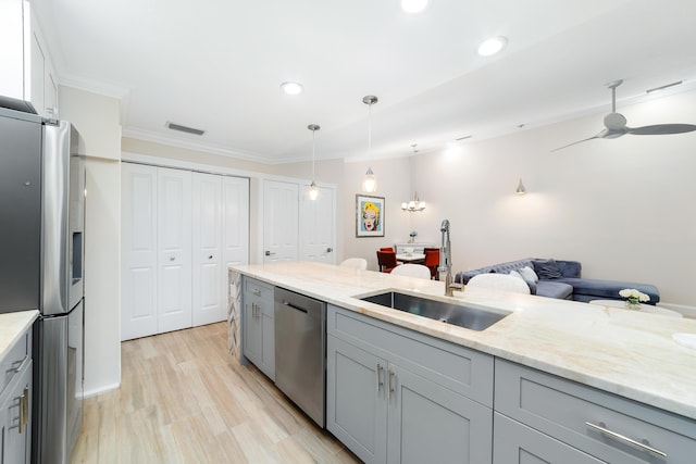 kitchen featuring pendant lighting, sink, gray cabinets, appliances with stainless steel finishes, and light stone countertops