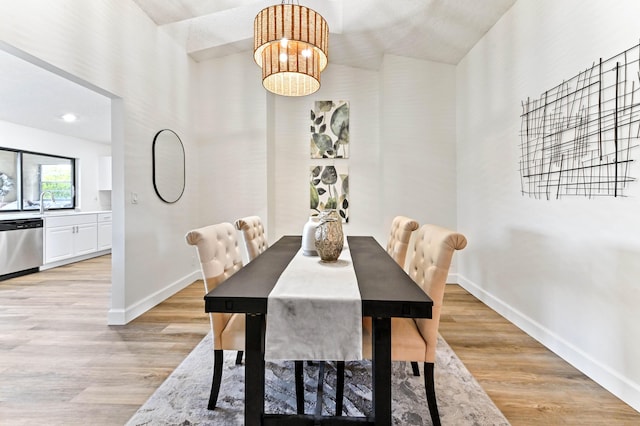 dining area with light hardwood / wood-style flooring and a chandelier