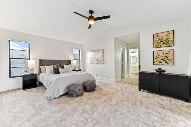 carpeted bedroom featuring ceiling fan, lofted ceiling, and ensuite bathroom