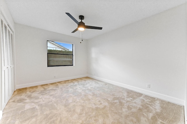 unfurnished bedroom featuring ceiling fan, a closet, and light carpet