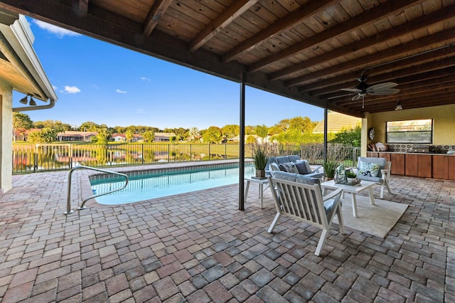 view of pool with a patio area, outdoor lounge area, ceiling fan, and a water view