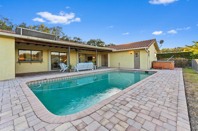 view of swimming pool featuring a hot tub and a patio area