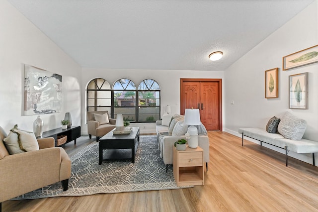 living room with hardwood / wood-style flooring, lofted ceiling, and a textured ceiling