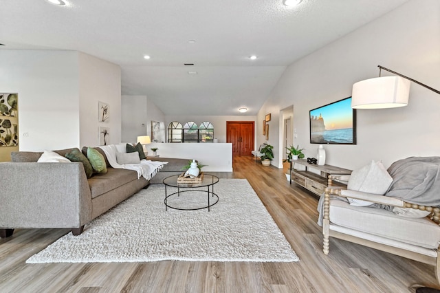 living room with vaulted ceiling and light hardwood / wood-style flooring