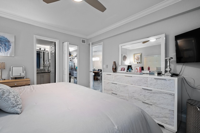 bedroom featuring a walk in closet, a closet, ornamental molding, ceiling fan, and ensuite bathroom