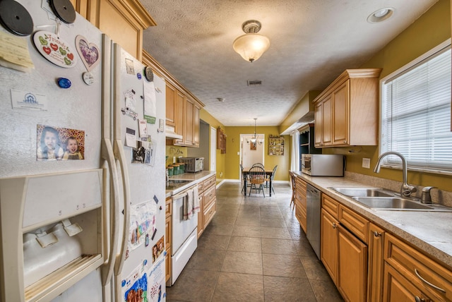 kitchen featuring decorative light fixtures, sink, an inviting chandelier, white appliances, and a textured ceiling