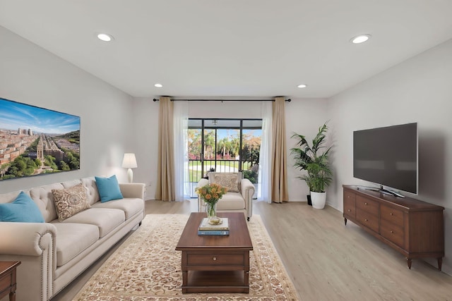 living area with light wood-style flooring and recessed lighting