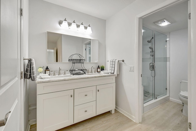 bathroom featuring hardwood / wood-style floors, an enclosed shower, vanity, and toilet