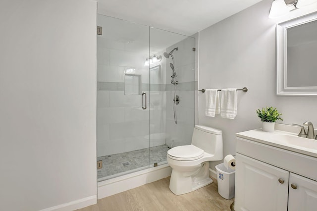 bathroom featuring wood-type flooring, toilet, vanity, and an enclosed shower