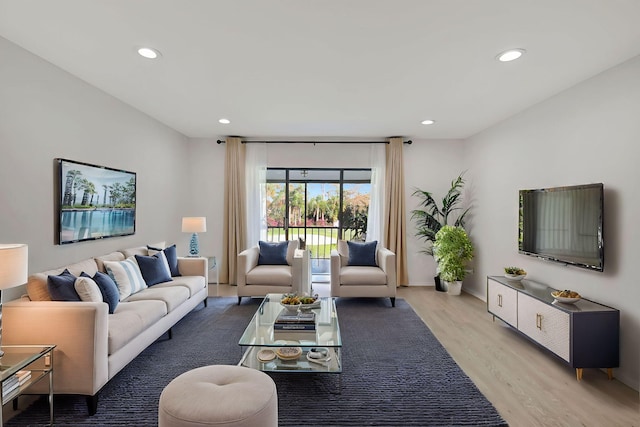 living area with baseboards, recessed lighting, and light wood-type flooring