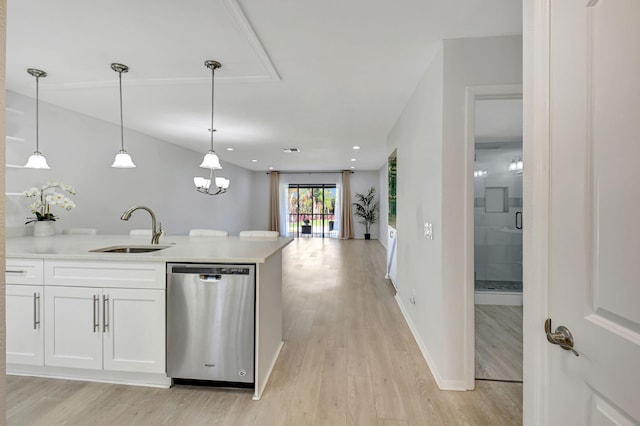 kitchen featuring decorative light fixtures, white cabinetry, sink, stainless steel dishwasher, and light hardwood / wood-style flooring