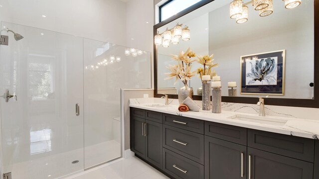 bathroom featuring a shower with shower door, vanity, and tile patterned floors