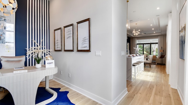 corridor featuring a chandelier and light hardwood / wood-style floors