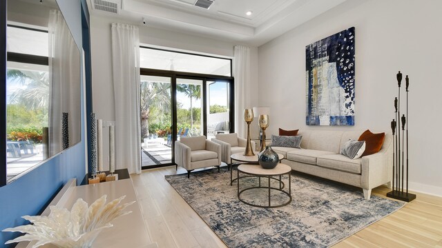 living room featuring hardwood / wood-style flooring and a tray ceiling