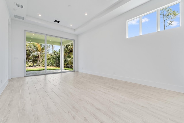 359 SE Via Sangro, Port Saint Lucie, FL 34952 - spare room with a tray ceiling, baseboards, light wood-style flooring, and recessed lighting