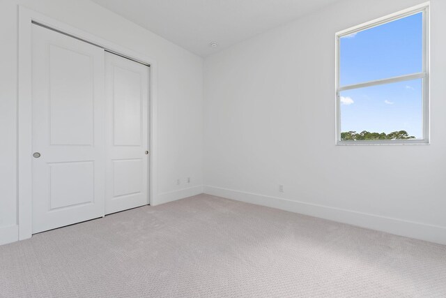 359 SE Via Sangro, Port Saint Lucie, FL 34952 - unfurnished bedroom with light carpet, multiple windows, and a closet