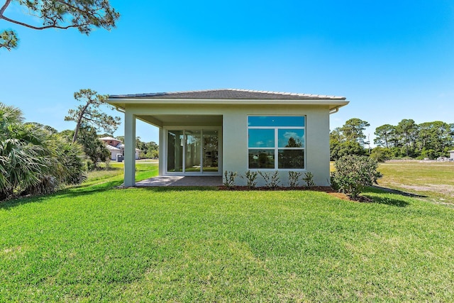 359 SE Via Sangro, Port Saint Lucie, FL 34952 - back of house featuring a lawn and stucco siding