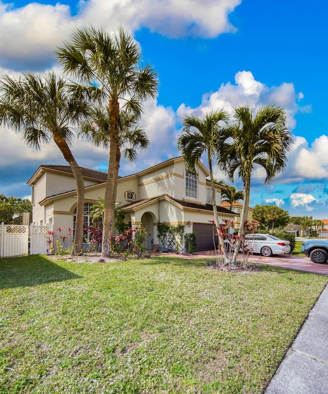 mediterranean / spanish-style home with a garage and a front lawn