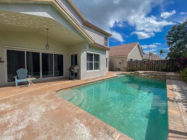 view of swimming pool with a patio, fence, a pool with connected hot tub, and a grill