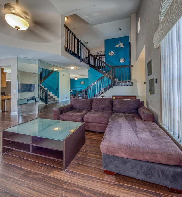 living room with a high ceiling and dark wood-type flooring