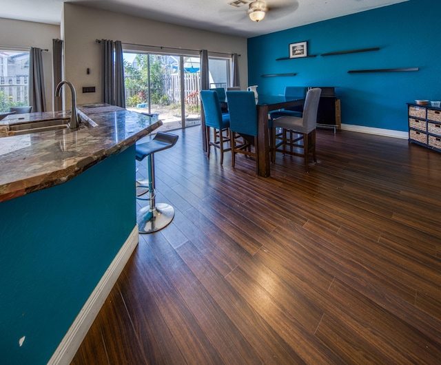 dining room with a ceiling fan, dark wood-style flooring, visible vents, and baseboards