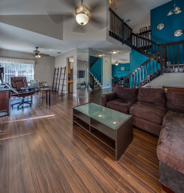 stairway featuring ceiling fan, high vaulted ceiling, hardwood / wood-style floors, and a textured ceiling