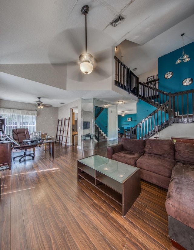 living room featuring visible vents, stairway, dark wood finished floors, and a ceiling fan