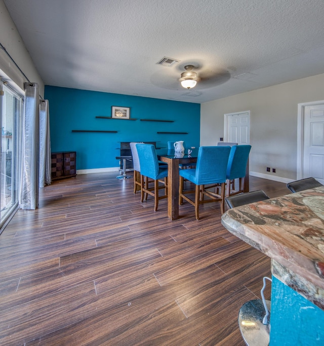 dining room with dark hardwood / wood-style floors and a textured ceiling