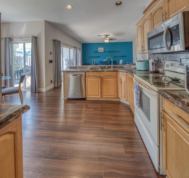 kitchen featuring dark hardwood / wood-style flooring, sink, stainless steel appliances, and kitchen peninsula