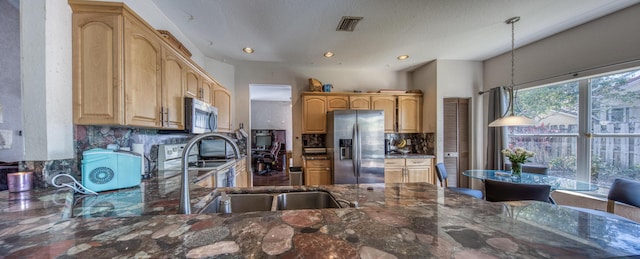 kitchen with decorative light fixtures, tasteful backsplash, visible vents, appliances with stainless steel finishes, and dark stone countertops