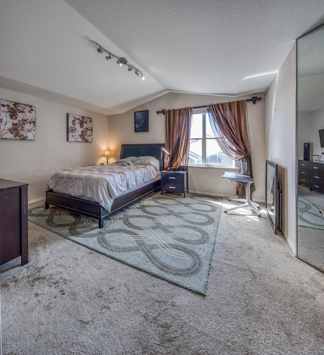 bedroom featuring carpet, baseboards, lofted ceiling, and a textured ceiling