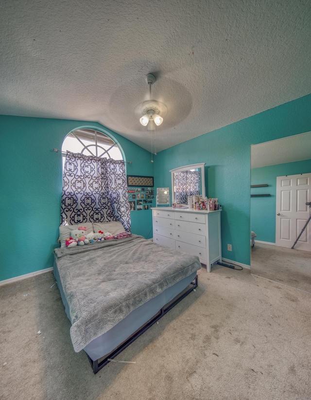 bedroom with ceiling fan, light colored carpet, and a textured ceiling