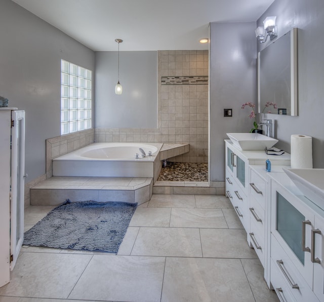 bathroom featuring a garden tub, double vanity, a sink, tile patterned flooring, and tiled shower