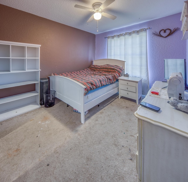 carpeted bedroom featuring ceiling fan and a textured ceiling