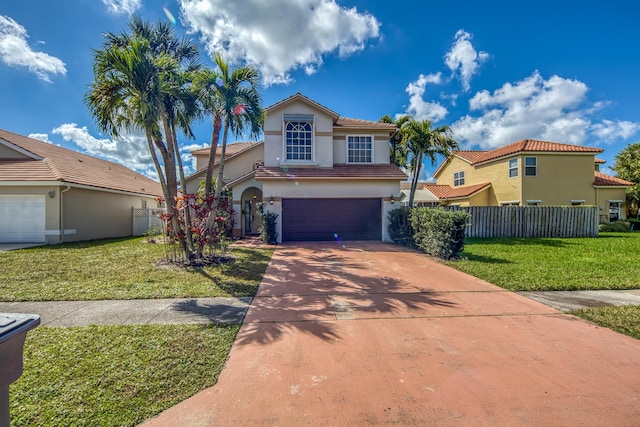 mediterranean / spanish home featuring stucco siding, an attached garage, a front yard, fence, and driveway