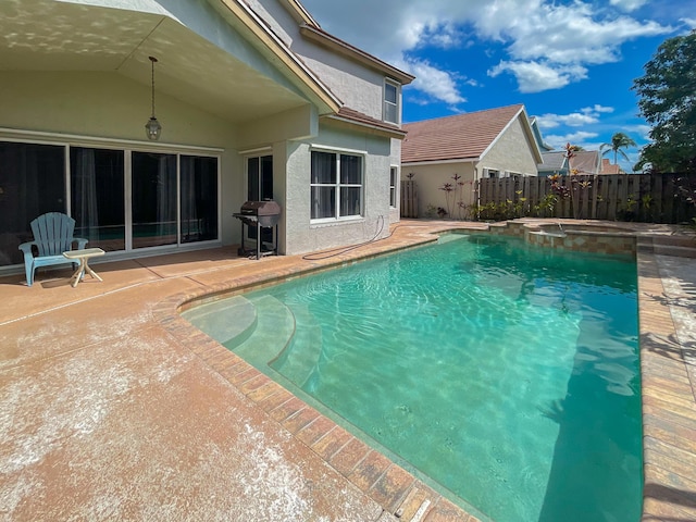 view of swimming pool with a patio area, area for grilling, fence, and a pool with connected hot tub