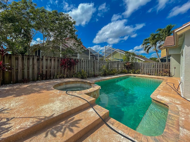 view of pool with a fenced backyard and a pool with connected hot tub